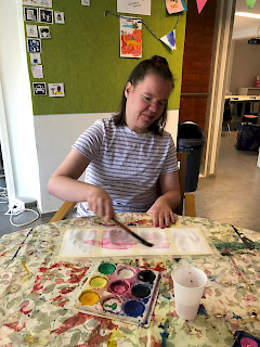 Nuori nainen maalaa vesivärimaalausta