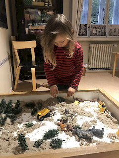 Lapsi leikkii museossa hiekkaleikkejä.