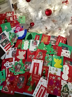 Kuvassa näkyy askarreltuja joulukortteja ja valkoinen joulukuusi.