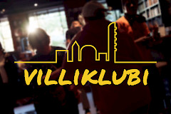 Keltainen Villiklubiteksti kaupunkisiluetin alla. Takana näkymä baarista.