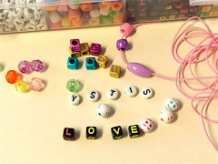 Helmiä ja helminauhaa. Helmistä on kirjoitettu sana "love".