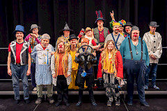 Ihmisiä rivissä erilaiset asut päällä.