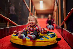 Lapsi laskee liukumäkeä leikkiluolassa.